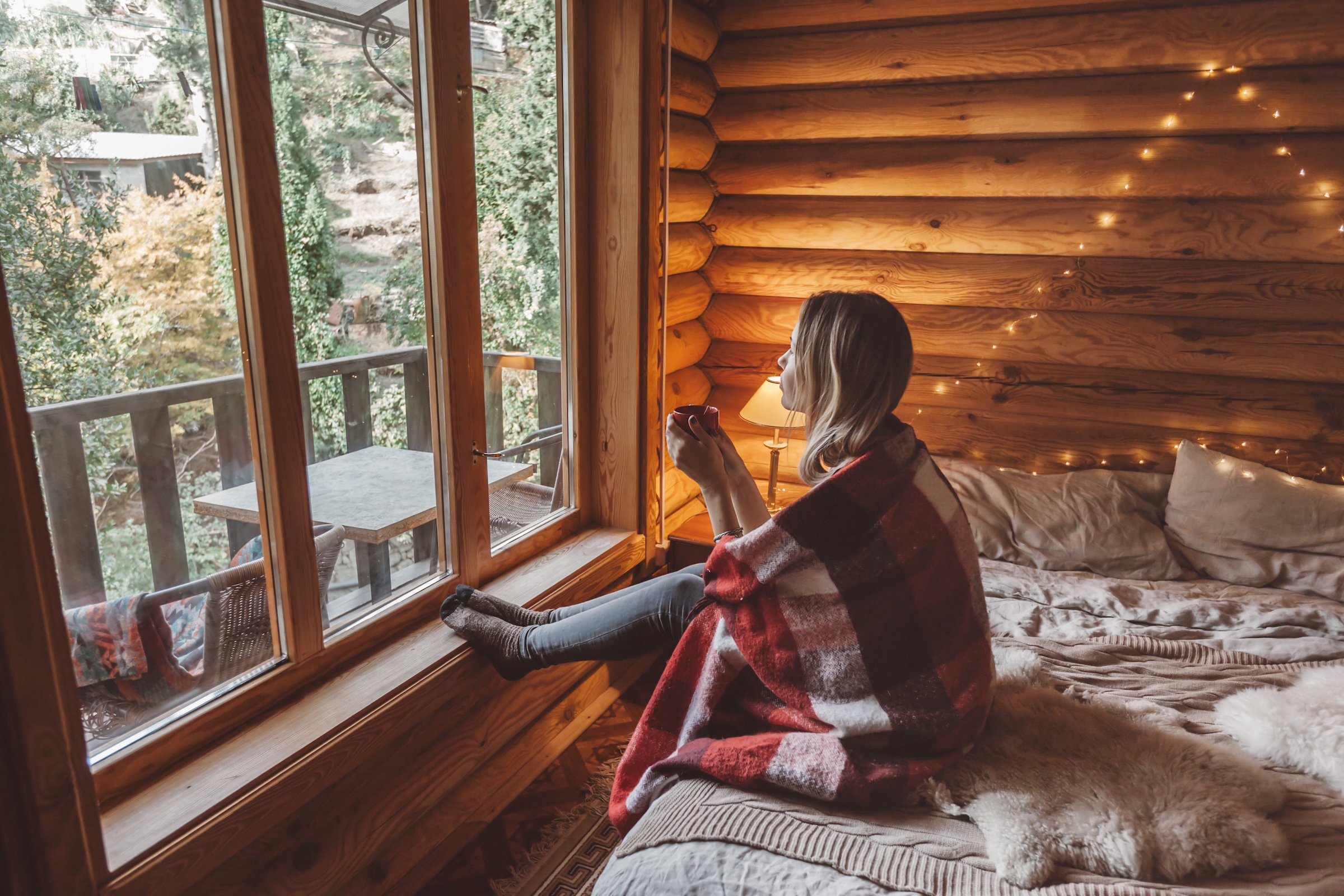 Femme se détendant avec une boisson chaude dans un chalet en nature au Québec