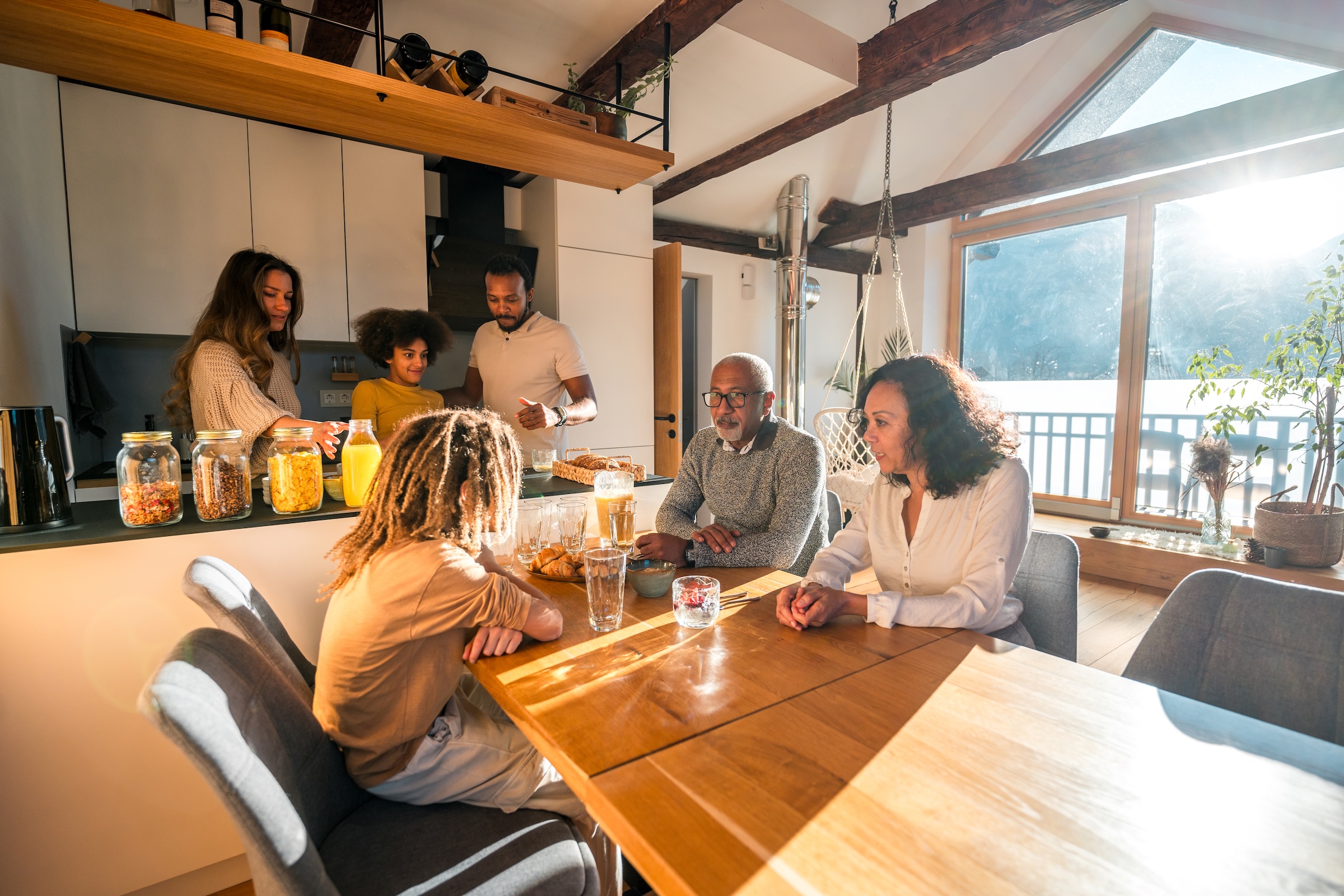 Famille réunie autour de la table dans la cuisine lumineuse d’un chalet au Québec.
