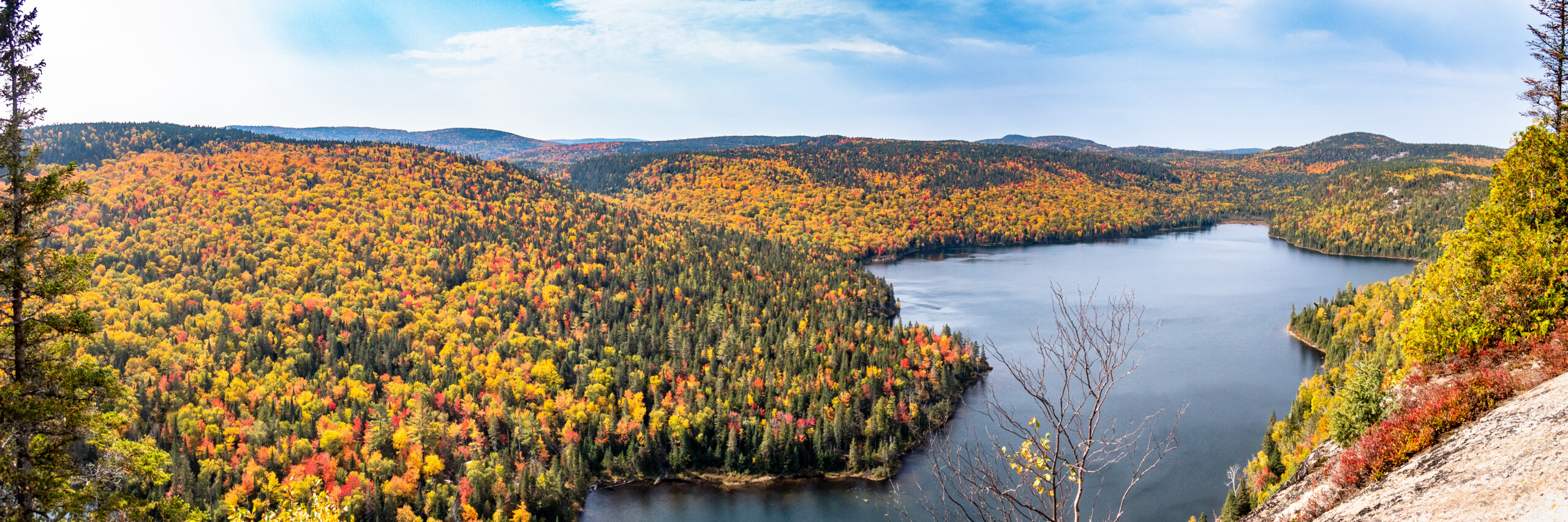 Vue panoramique d’un lac entouré de forêts aux couleurs d’automne dans Lanaudière